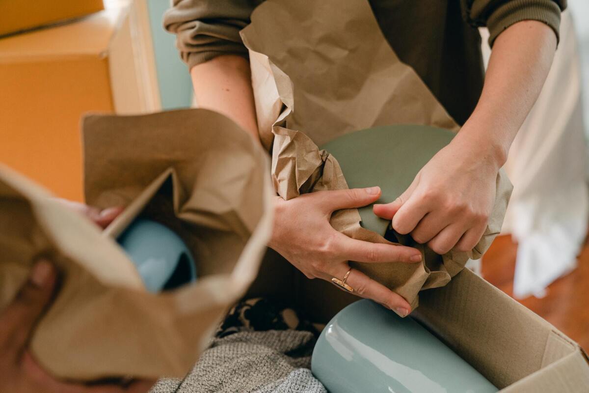 Partijhandel particulier - man en vrouw die spullen beschermen met bruin papier